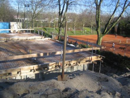 Zicht op de bouw vanaf de tennisbaan